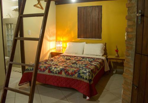 Un dormitorio con una cama con una escalera. en Villa Justen Pousada en Lençóis