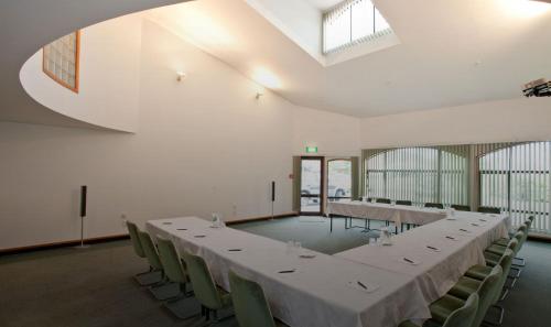 a large room with a long table and chairs at Distinction Mackenzie Country Hotel in Twizel