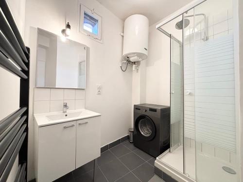 une salle de bain avec une machine à laver et un lavabo dans l'établissement Spacieux appartement pour 6 voyageurs - Roubaix, à Roubaix