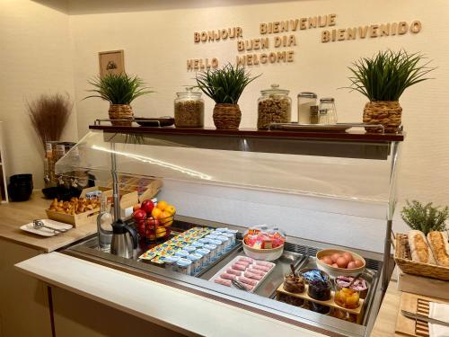 a display case with different types of food at Abelha Hôtel Le France in Brive-la-Gaillarde