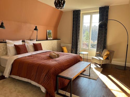 une chambre avec un grand lit et une fenêtre dans l'établissement La Maison Normande, à Saint-Cirgues-de-Jordanne