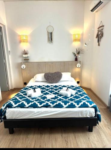 une chambre avec un lit avec une couette bleue et blanche dans l'établissement L'Alizia, à Sari-Solenzara