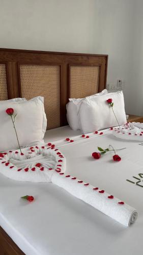 two beds with red rose pedals on them at Mia Boutique Hotel in Michamvi