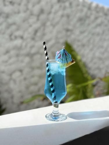 a glass with a blue drink with a straw at Mia Boutique Hotel in Michamvi