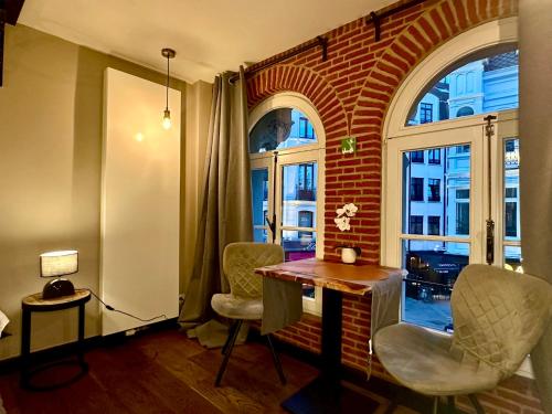 a room with a brick wall and a table and chairs at Luxury Suites Historic Center by Rikas Hotels in Antwerp