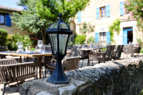 a blue street light on a stone wall with tables and chairs at La Bastide Bleue in Séguret