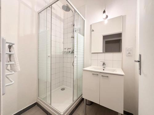 une salle de bain blanche avec une douche et un lavabo dans l'établissement Hypercentre de Roubaix - 4 voyageurs, à Roubaix