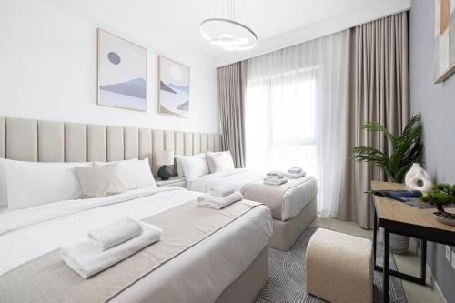 a hotel room with two beds and a desk at Fresh New 2 Bedroom! Amazing Burj Khalifa View! 5-star Pool & Gym Access! in Dubai