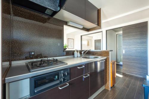 a kitchen with a sink and a stove at Cozy Stay Sapporo Maruyama in Sapporo