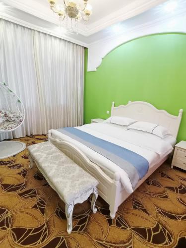 a bedroom with a large bed and a green wall at Emeishan Moon Bay Hotel in Emeishan