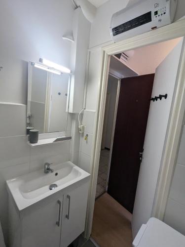 une salle de bain avec un lavabo et un miroir dans l'établissement Studio Rue Castellane pour Cure ou Tourisme Vert à 2 min des Thermes, à Amélie-les-Bains-Palalda