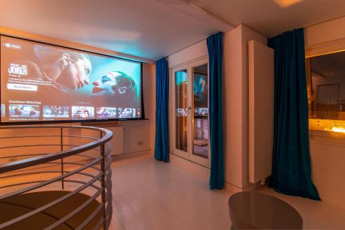 a living room with a large screen tv in a room at Plaka Villa with Epic Acropolis Views in Athens