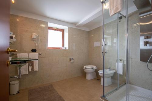 a bathroom with a toilet and a glass shower at Hotel San Luca in Battipaglia