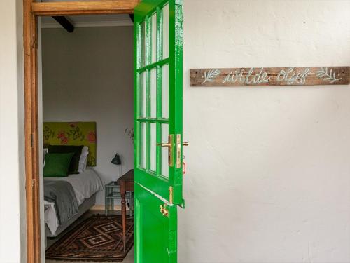 a green door leading to a bedroom with a bed at Beloftebos Farm Cottages in Papiesvlei