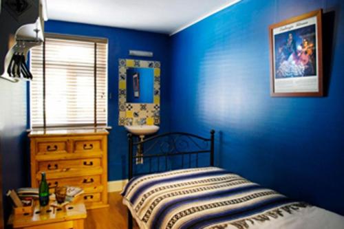 a blue bedroom with a bed and a dresser at Dancenter South London Camberwell in London