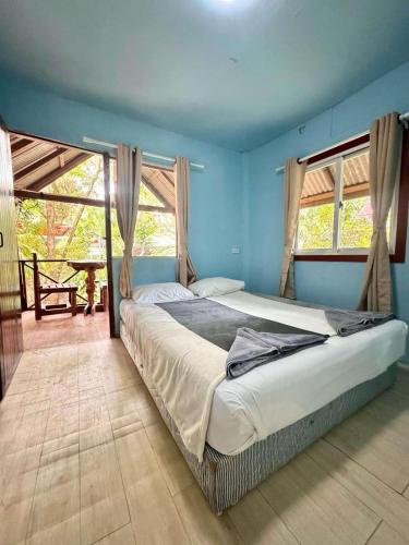a bedroom with a large bed with blue walls at Khaosok Island Resort in Khao Sok National Park