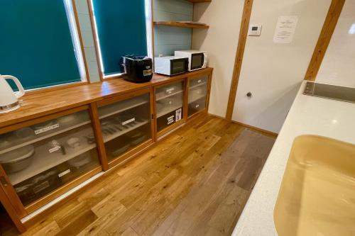 萨摩川内市Nishikata Beach House 1 -西方海岸貸別荘 壱号-的带玻璃抽屉柜台的厨房