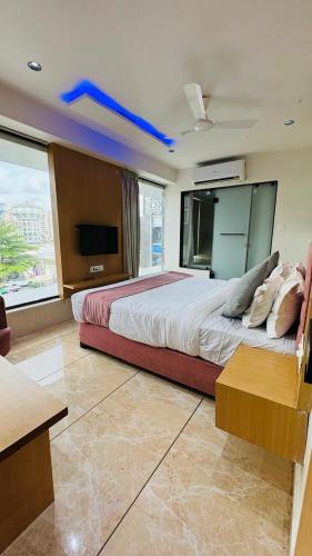 a bedroom with a large bed with a blue ceiling at Hotel Cozzy Palace in Surat