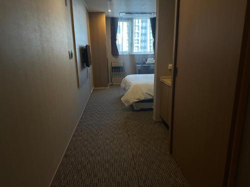 a hotel room with a bed and a window at Golden Harbor Hotel Pyeongtaek in Pyeongtaek