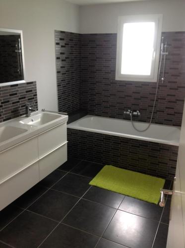 La salle de bains est pourvue d'une baignoire et d'un tapis vert. dans l'établissement Mas Rémy-Villa in private residence, à Saint-Rémy-de-Provence