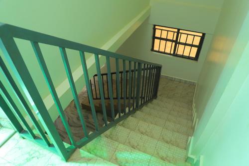 a staircase with a crib in a room with a window at Duggers Motel Lusaze in Kampala