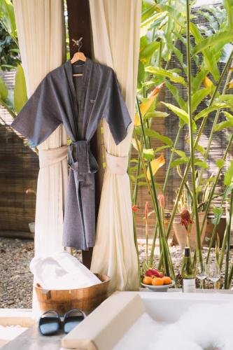 a robe hanging on a curtain in a bathroom at Le Sen Boutique Hotel in Luang Prabang
