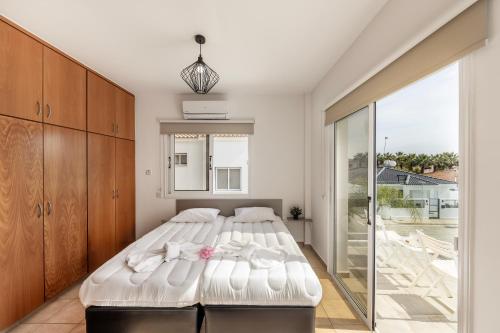 a bedroom with a bed and a sliding glass door at Villa Antonieta in Ayia Napa