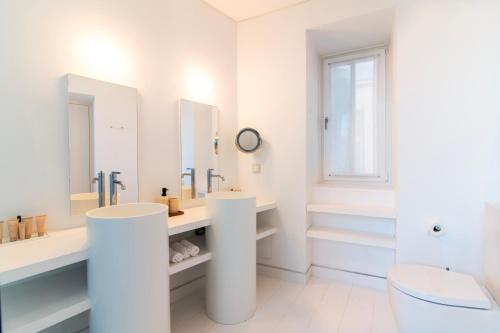 a white bathroom with two sinks and mirrors at Plaka Villa with Epic Acropolis Views in Athens