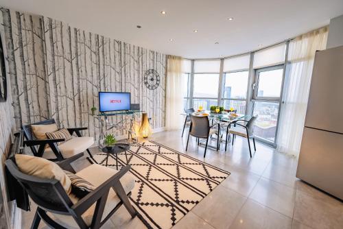 a living room with a table and chairs and a television at Luxurious PENTHOUSE SUITE with Panoramic Views & FREE Parking in Cardiff City Centre in Cardiff