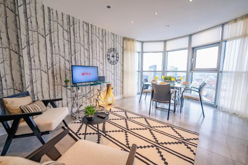 a living room with a couch and a dining room at Luxurious PENTHOUSE SUITE with Panoramic Views & FREE Parking in Cardiff City Centre in Cardiff