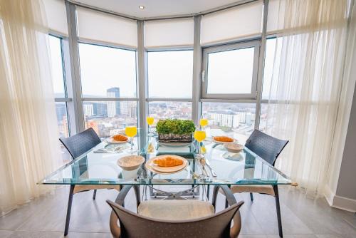 a glass table with food on it in a room with windows at Luxurious PENTHOUSE SUITE with Panoramic Views & FREE Parking in Cardiff City Centre in Cardiff