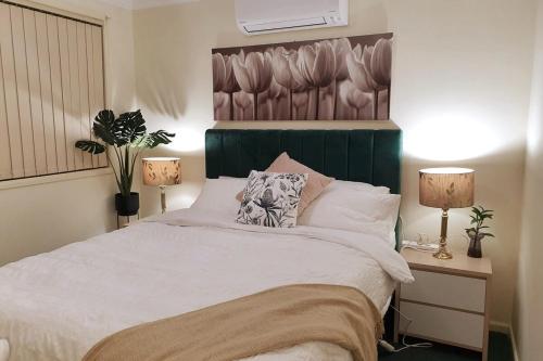 WorrageeStylish Home 3mins walk to Worrigee Medical Centre with Free Parking的卧室里有一张白色的大床，床边还有两盏灯
