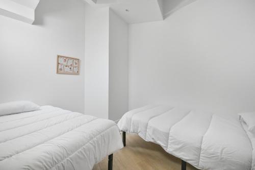 deux lits côte à côte dans une chambre dans l'établissement Grand Loft Spacieux Paris 8 Pers WIfi CDG, à Bagnolet