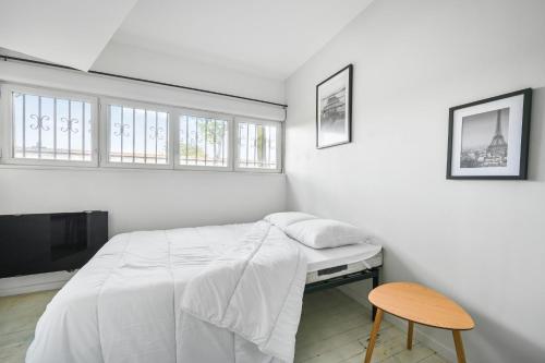 une chambre blanche avec un lit et une chaise dans l'établissement Grand Loft Spacieux Paris 8 Pers WIfi CDG, à Bagnolet