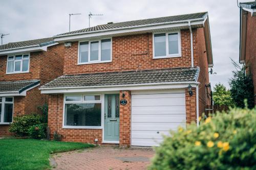 a brick house with a white garage at Wiske House Free Parking & Fast WiFi in Stockton-on-Tees