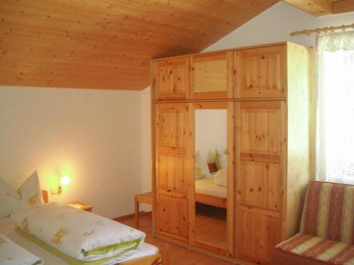 a bedroom with a large wooden cabinet with a bed at Gmosnhof Mölten in Meltina