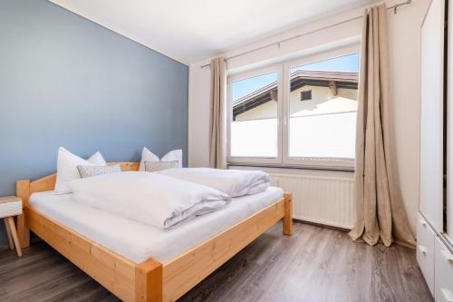 a bedroom with a bed and a large window at Linde Apartment in Reutte