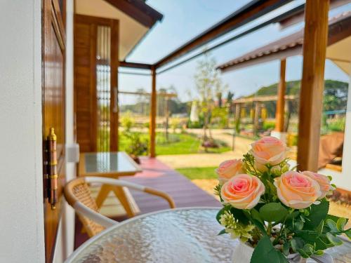 Ban Chae Phang (1)にあるชีววิถีเฮิร์บ เวลเนส สเตย์の玄関のガラス台の上のバラの花瓶