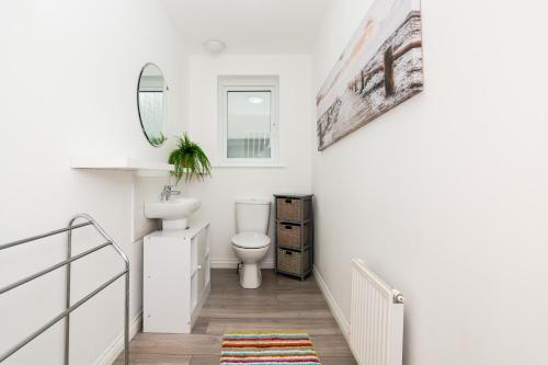 a white bathroom with a toilet and a sink at 3 Bedroom House-Private Parking in Bonnyrigg
