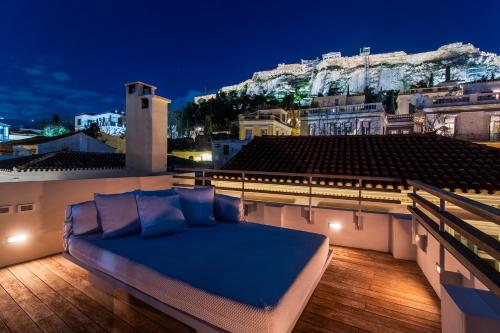 a bed on the balcony of a building at night at Plaka Villa with Epic Acropolis Views in Athens