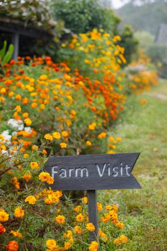 a sign in front of a field of flowers at Prakriti Resort and Organic Farm Pvt. Ltd. in Burhānilkantha