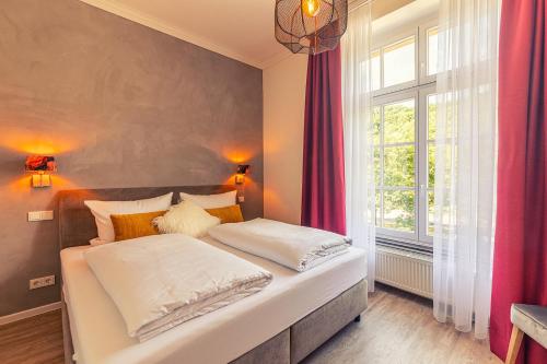 two beds in a bedroom with a large window at Rochter Landhotel in Zeltingen-Rachtig