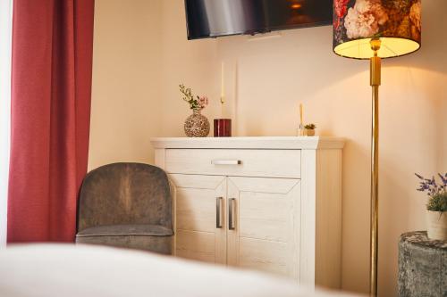 a room with a chair and a white cabinet at Rochter Landhotel in Zeltingen-Rachtig