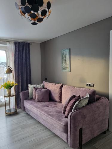 a purple couch in a living room with at Few Steps to the Bay in Jūrmala