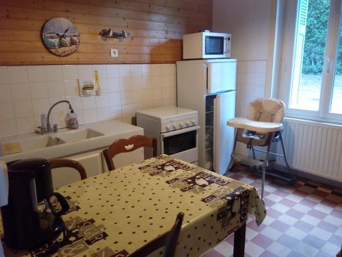 eine Küche mit Tisch, Spüle und Kühlschrank in der Unterkunft Grande maison familiale, calme, tranquille, 900 m de la plage in Longeville-sur-Mer