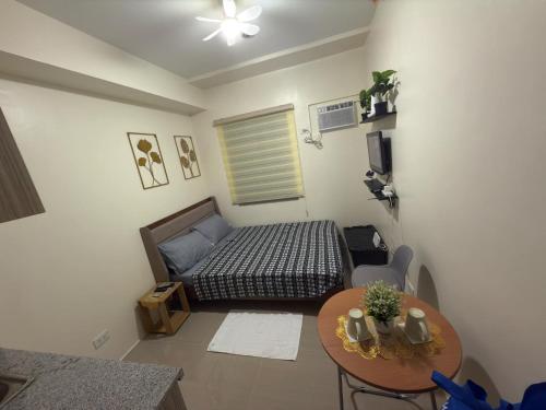 una pequeña habitación con una cama y una mesa en Condo in Cubao by Cindy, en Manila