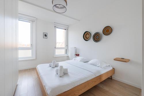 a white bedroom with a large bed with white sheets at L'Académie - Magnifique 3 chambres Krutenau avec parking in Strasbourg