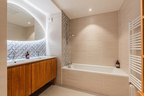 a bathroom with a tub and a sink at L'Académie - Magnifique 3 chambres Krutenau avec parking in Strasbourg