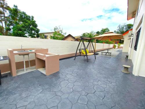 a patio with a bench and a swing at SunsetChalet 25pax Pool Snooker Bathtub Playground in Kluang