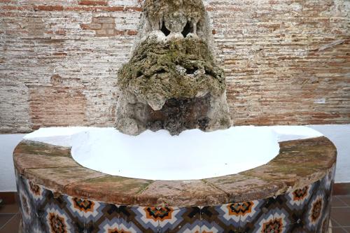 a fountain in front of a brick wall at Homenfun Dalt Badalona in Badalona